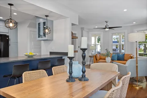 a dining room with wooden floor a glass table and chairs