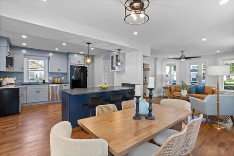 an open kitchen with dining table and stainless steel appliances