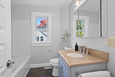 a bathroom with a toilet sink and mirror