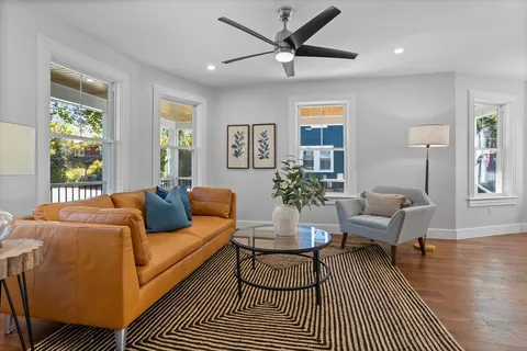 a living room with furniture and a wooden floor