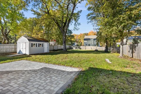 a view of a yard with a house and a large tree