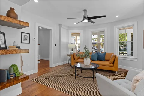 a living room with furniture and wooden floor
