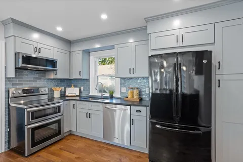 a kitchen with a refrigerator and a stove top oven