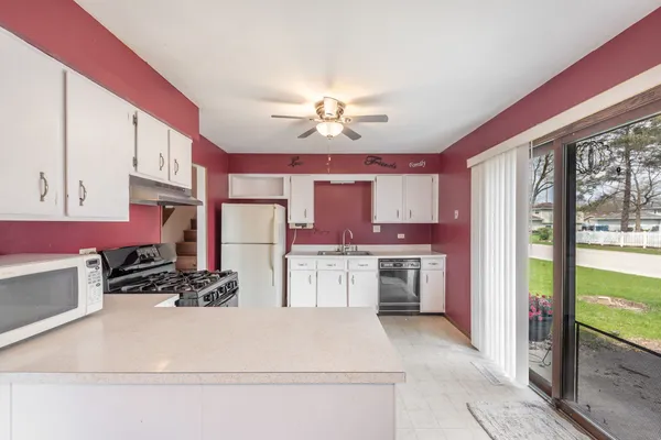 a kitchen with stainless steel appliances a stove a refrigerator sink cabinets and couches