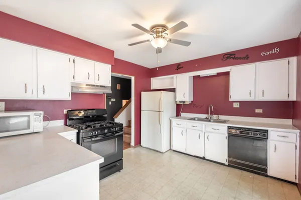 a kitchen with white cabinets and appliances