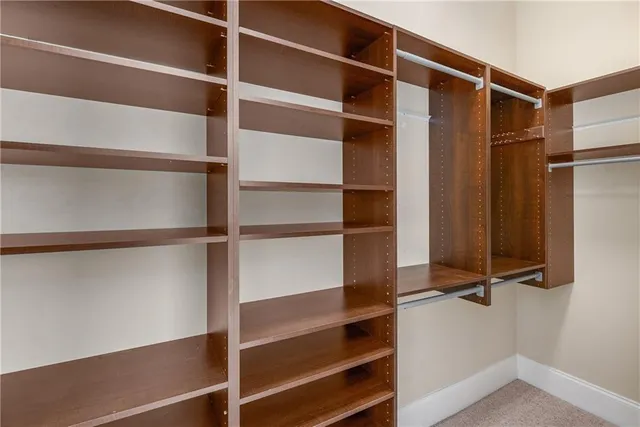 a view of walk in closet with empty racks