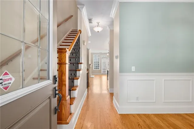 a view of a hallway with wooden floor and staircase