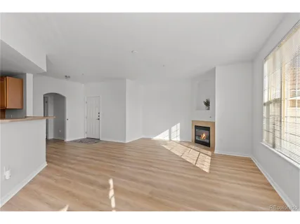 a view of empty room with wooden floor and fireplace