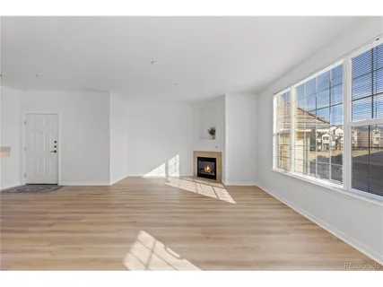 a view of empty room with wooden floor and fireplace