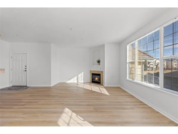a view of empty room with wooden floor and fireplace