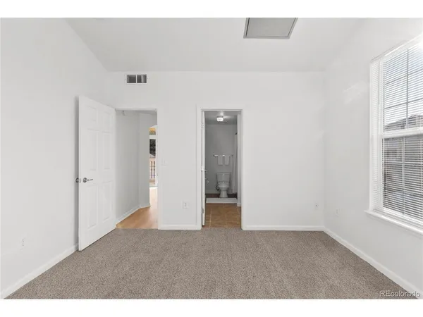 an empty room with windows and closet