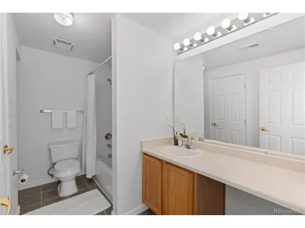 a bathroom with a sink mirror and a toilet