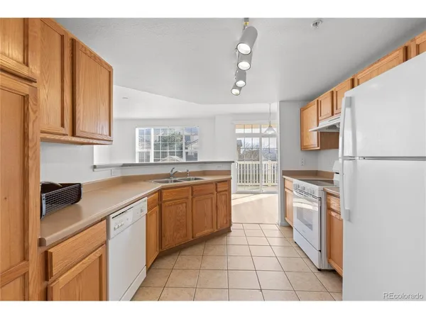 a kitchen with stainless steel appliances granite countertop a refrigerator a sink dishwasher a stove with wooden cabinets