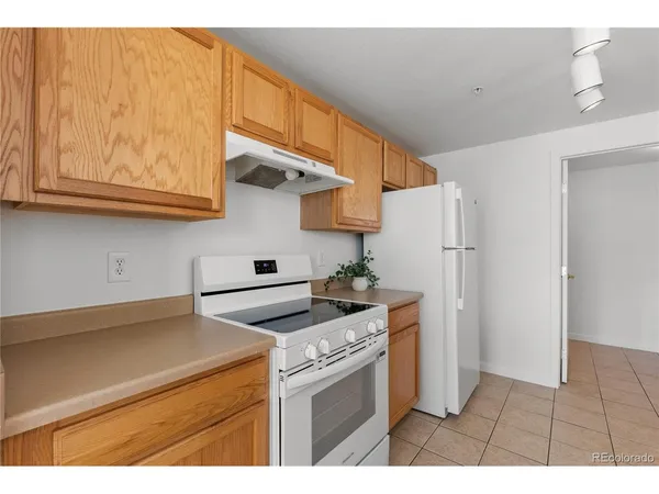 a kitchen with stainless steel appliances granite countertop a refrigerator a stove and a sink