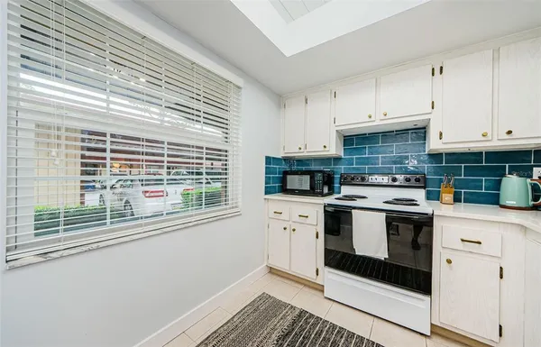 a kitchen with stainless steel appliances white cabinets and a stove top oven