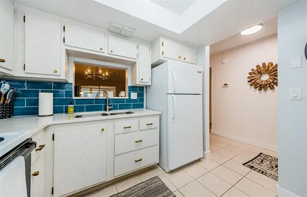 a kitchen with white cabinets and white appliances