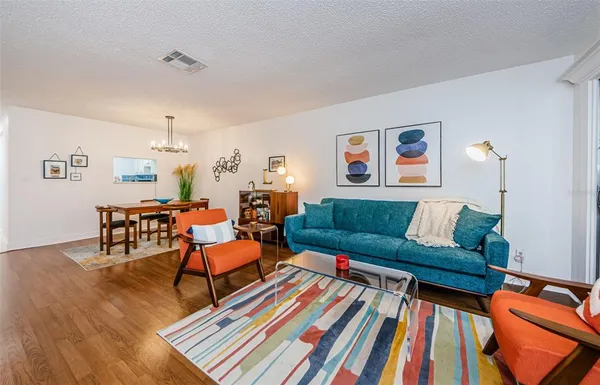 a living room with furniture and a wooden floor