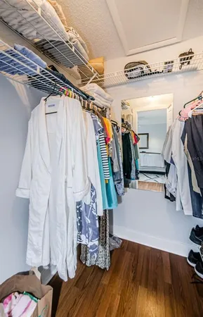 a view of walk in closet with clothes and shoes