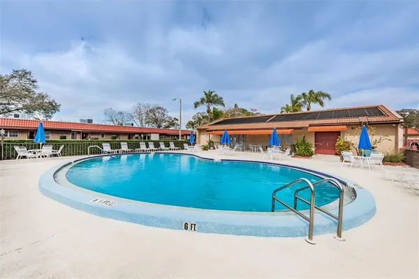 a view of swimming pool with outdoor seating and a garden