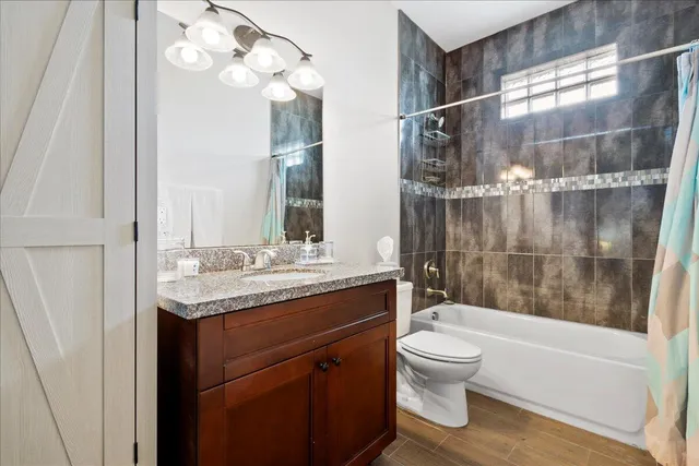a bathroom with a granite countertop sink a toilet and bathtub