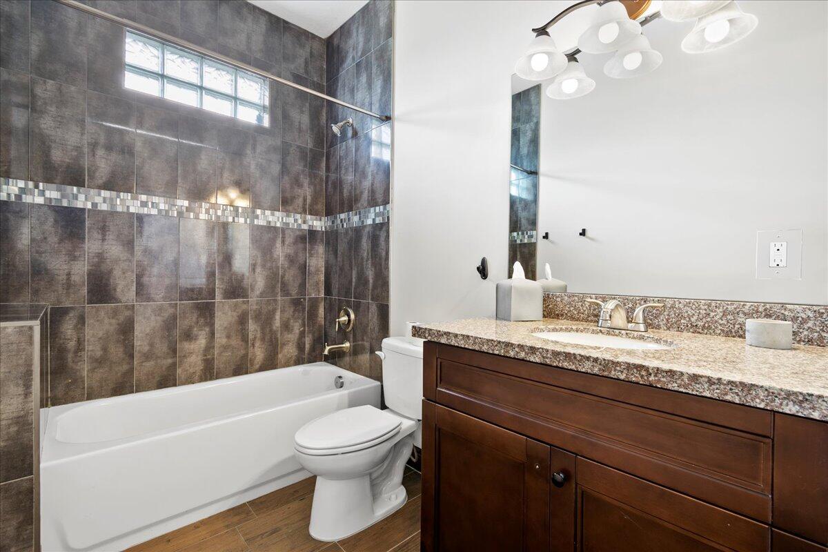 16575 Van Gogh Boulevard, Unit HORSE STALLS) Loxahatchee, FL 33470 - Photo 46 of 50 a bathroom with a granite countertop sink a toilet and bathtub