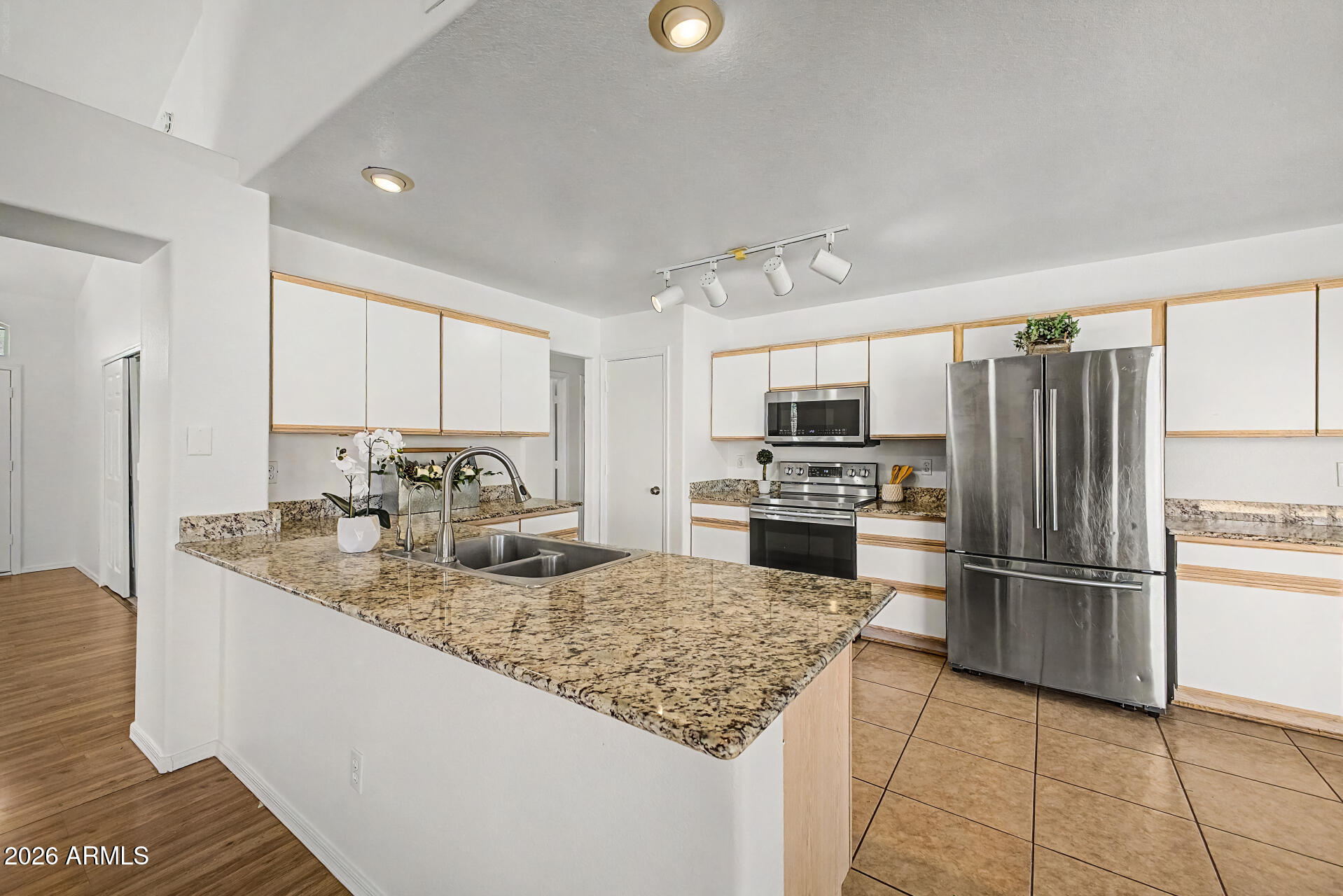 2762 North Ricardo Mesa, AZ 85215 - Photo 19 of 38 a kitchen with kitchen island granite countertop a sink cabinets and stainless steel appliances