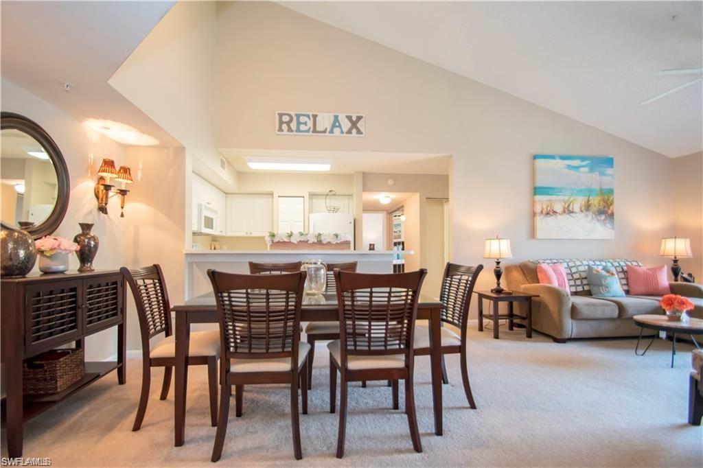 1220 Wildwood Lakes Boulevard, Unit 201 Naples, FL 34104 - Photo 1 of 35 Carpeted dining room featuring ceiling fan and lofted ceiling