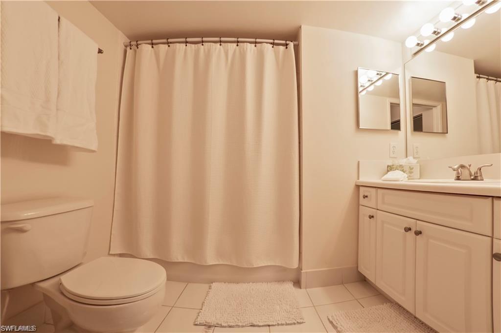 1220 Wildwood Lakes Boulevard, Unit 201 Naples, FL 34104 - Photo 22 of 35 Full bathroom with toilet, vanity, tile patterned floors, and shower / bathtub combination with curtain