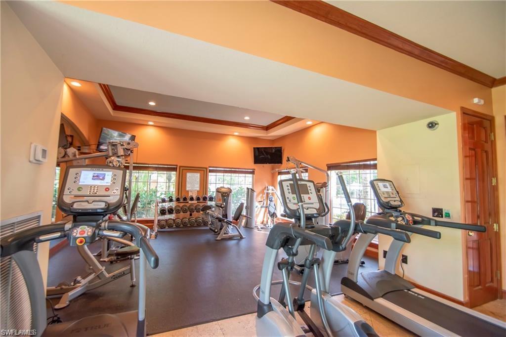 1220 Wildwood Lakes Boulevard, Unit 201 Naples, FL 34104 - Photo 27 of 35 Workout area featuring a tray ceiling, a healthy amount of sunlight, and ornamental molding