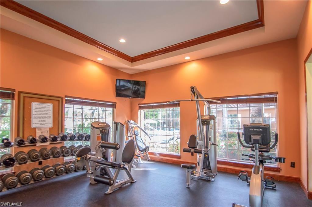 1220 Wildwood Lakes Boulevard, Unit 201 Naples, FL 34104 - Photo 28 of 35 Gym with a raised ceiling, a wealth of natural light, and crown molding