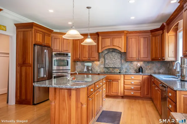 a large bed sitting in a bedroom next to a window and a chandelier