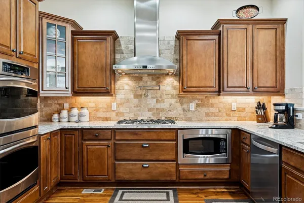 a kitchen with stainless steel appliances granite countertop a refrigerator and a stove