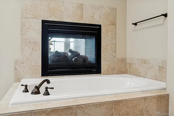 a bathroom with a tub sink and mirror