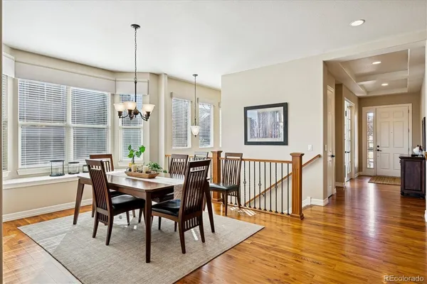 a dining room with furniture a chandelier and wooden floor