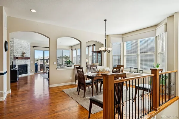 a kitchen with stainless steel appliances a refrigerator a stove top oven a sink cabinets and a dining table