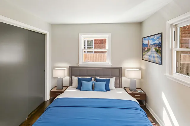 a spacious bedroom with a bed and wooden floor