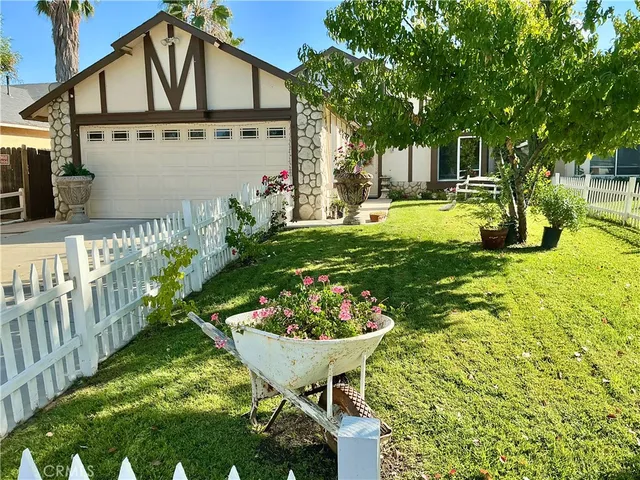 a view of a white house with a yard and plants