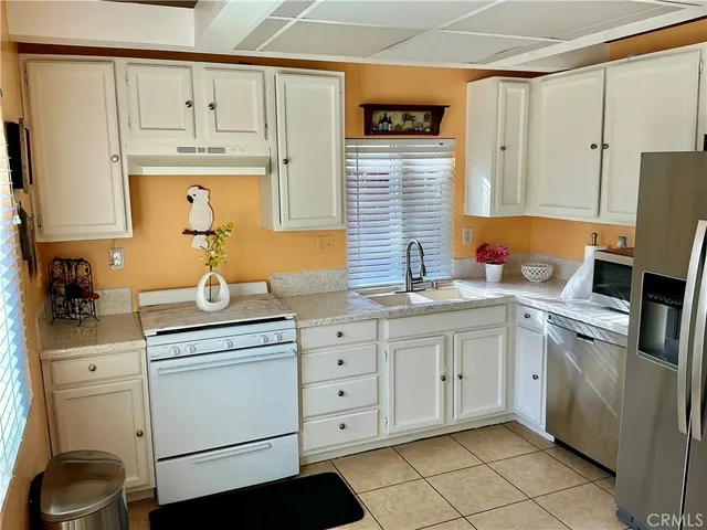 a kitchen with white cabinets and white appliances