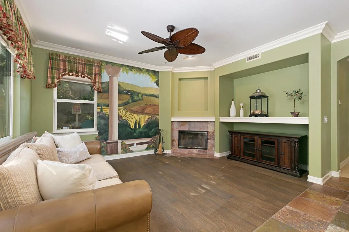 2902 Rancho Rio Chico Carlsbad, CA 92009 - Photo 11 of 30 a living room with furniture a fireplace and a large window with garden view