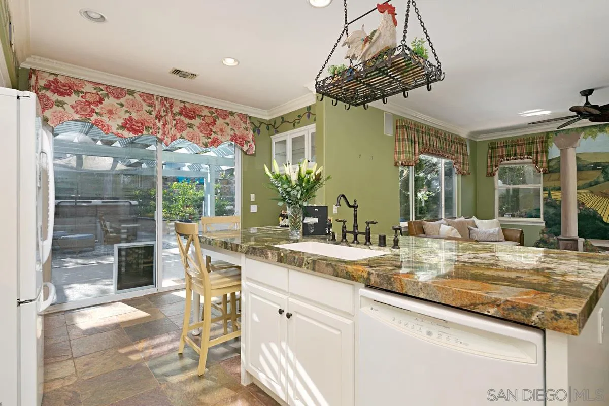2902 Rancho Rio Chico Carlsbad, CA 92009 - Photo 10 of 30 a kitchen with kitchen island granite countertop a sink and a counter top space