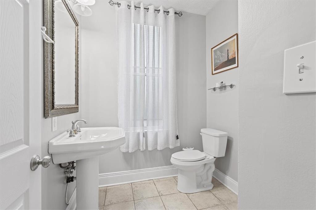 1302 Sarah Street Pittsburgh, PA 15203 - Photo 10 of 25 a bathroom with a toilet sink and mirror