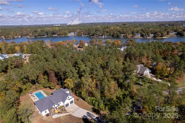 an aerial view of residential house with outdoor space and trees all around