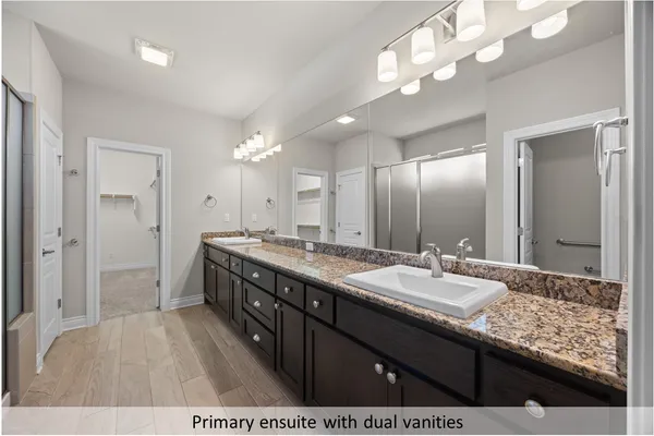 a spacious bathroom with a granite countertop sink a mirror and a shower