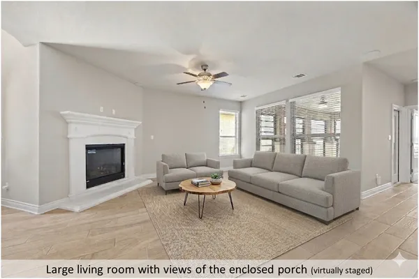 a living room with furniture a fireplace and a large window