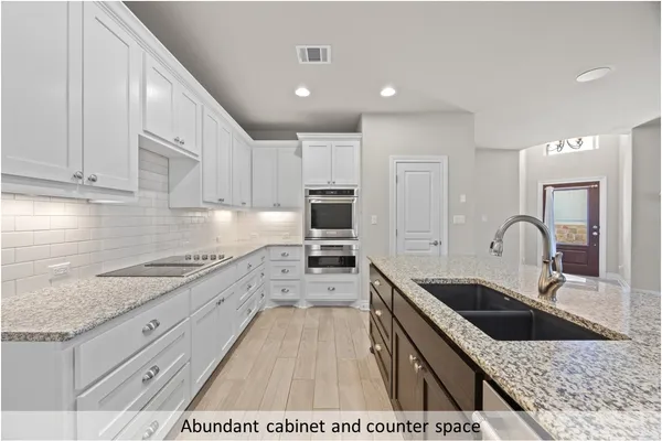 a kitchen with granite countertop a sink stainless steel appliances and cabinets