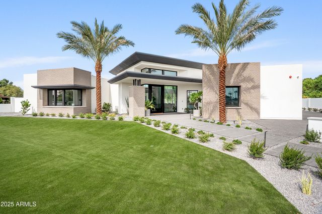 a view of a patio with couches and table potted plants and large tree