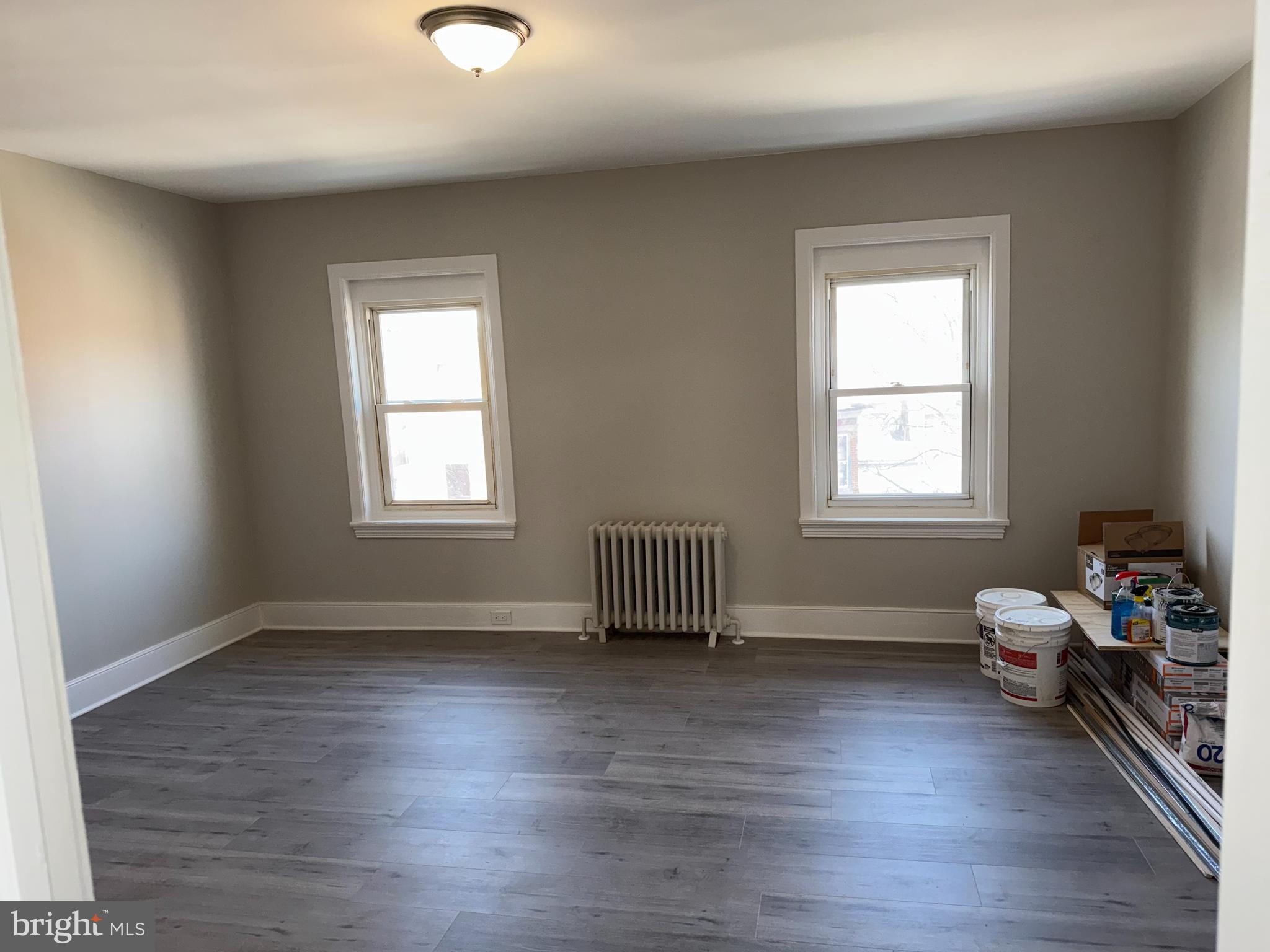 an empty room with wooden floor and a window