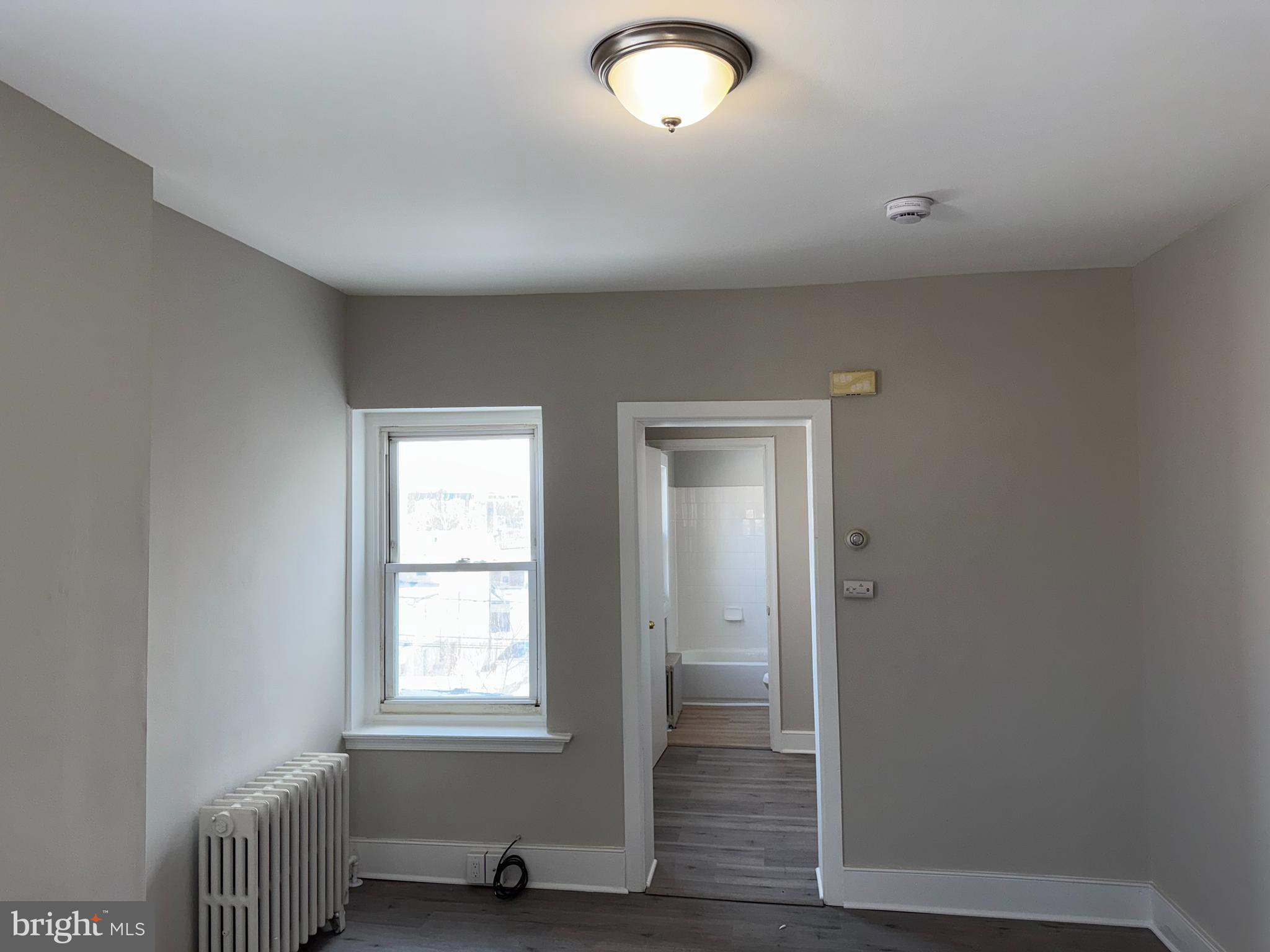 706 Chain Street, Unit 3 Norristown, PA 19401 - Photo 15 of 15 an empty room with wooden floor and windows