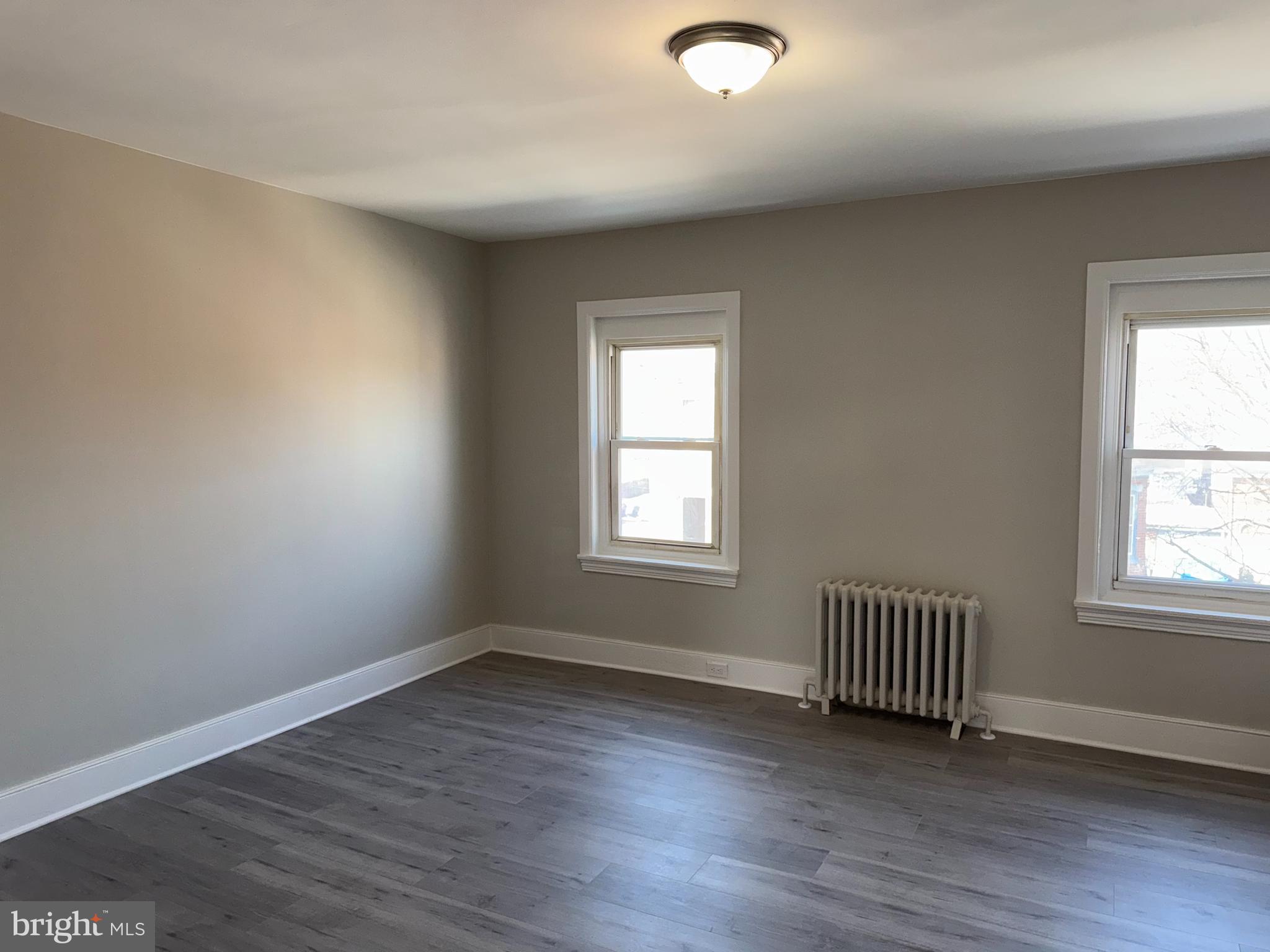 706 Chain Street, Unit 3 Norristown, PA 19401 - Photo 2 of 15 an empty room with wooden floor and windows