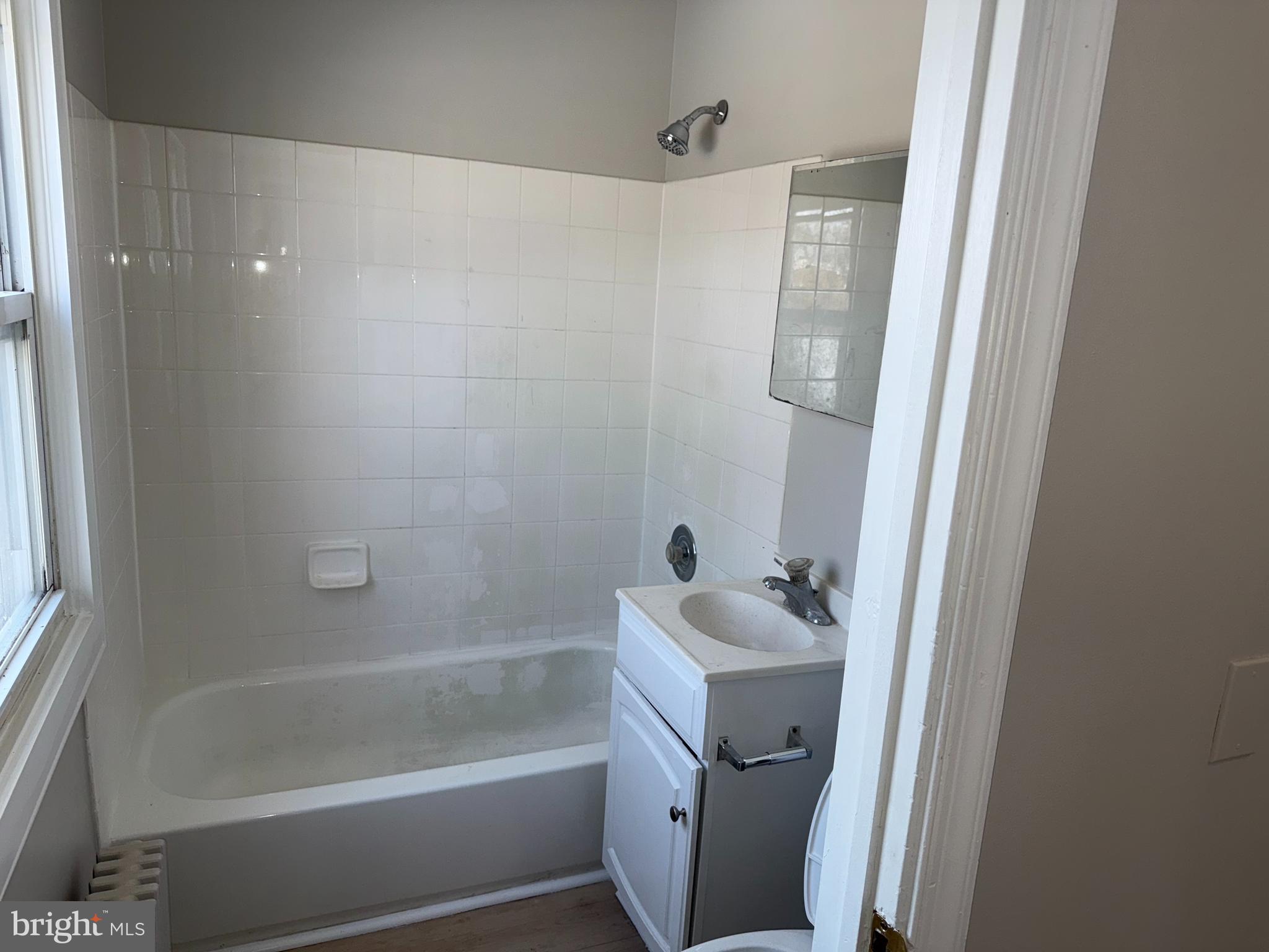 706 Chain Street, Unit 3 Norristown, PA 19401 - Photo 10 of 15 a bathroom with a sink a mirror a bathtub and shower